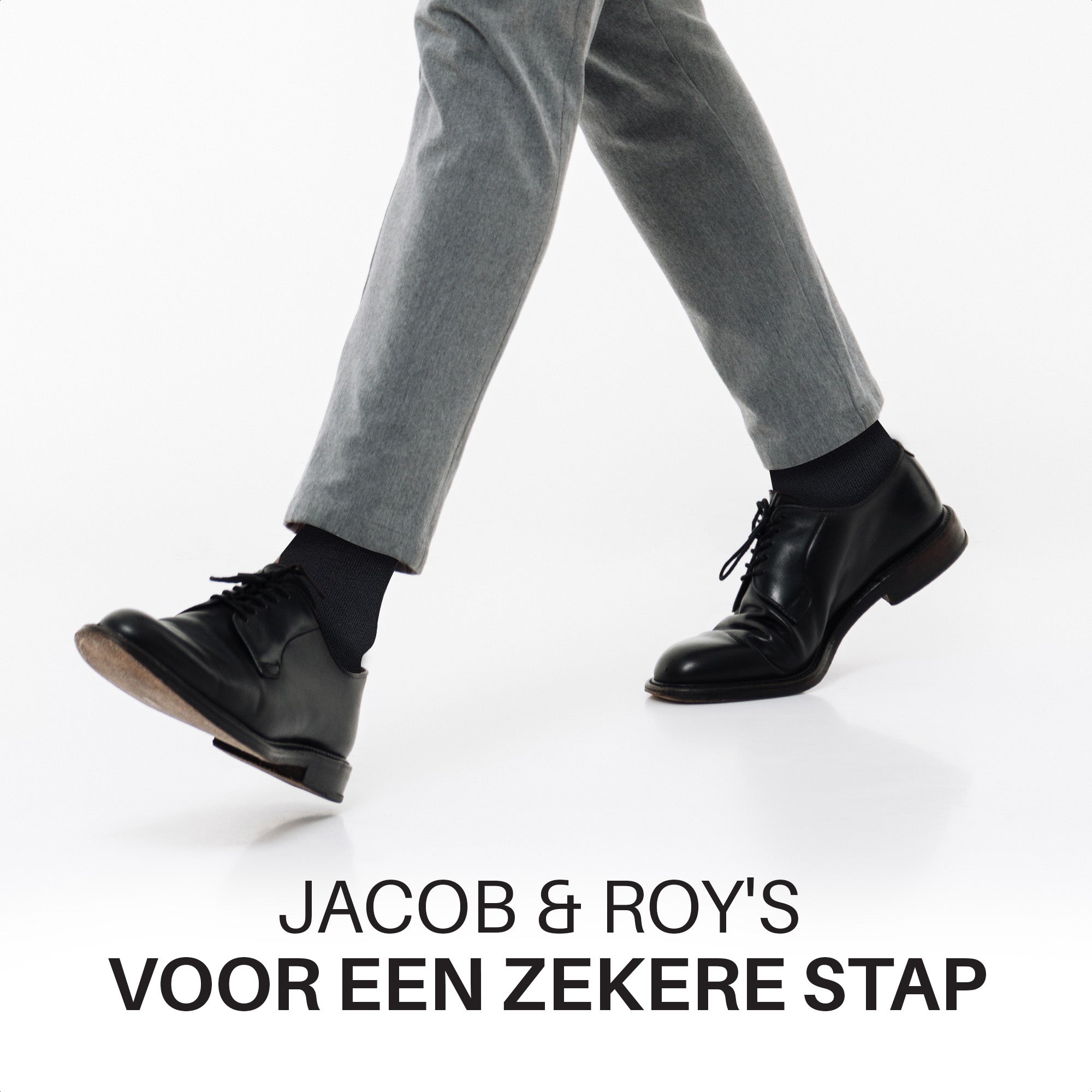 Benen in grijze pantalon met zwarte sokken en nette schoenen tijdens het lopen