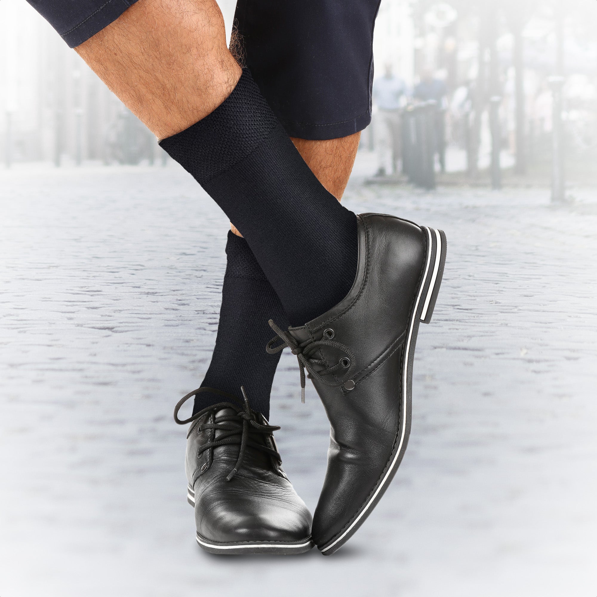 Zwarte sokken gedragen bij nette schoenen, buiten aan het water